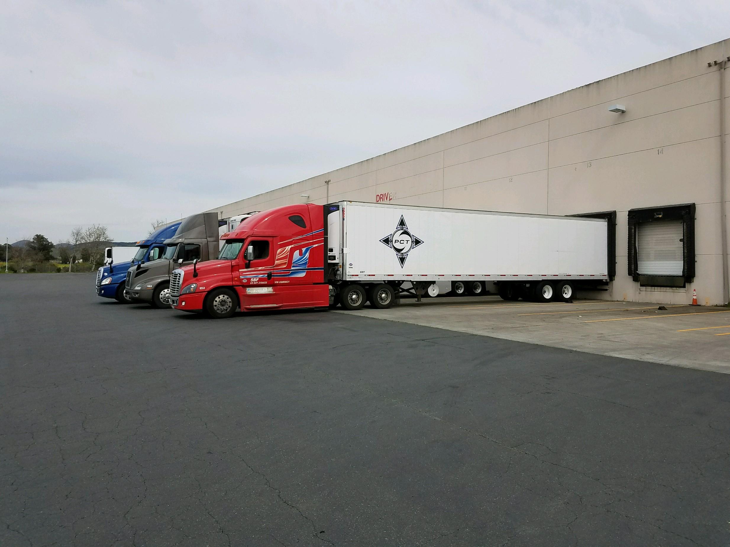 CalifoniaWineTransportLTL-Napa-PCT-Trucks side profile of red truck with p.c.t. logo on the side